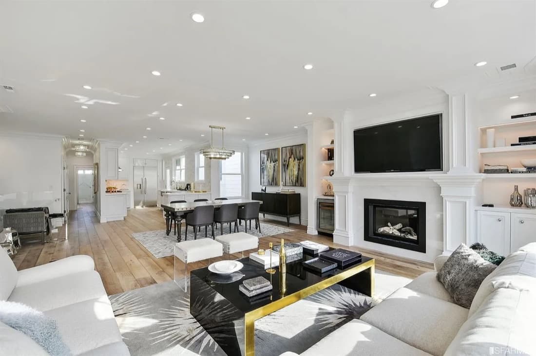 Open-plan living room at 3316–3320 Scott Street with a marble fireplace, dining area and kitchen beyond